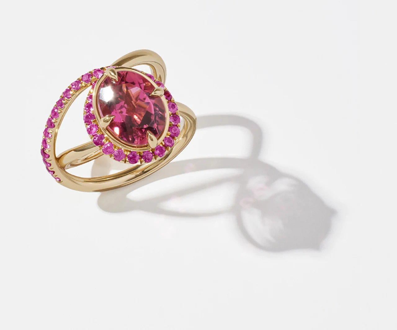 Gold ring with a pink gemstone and a soft shadow