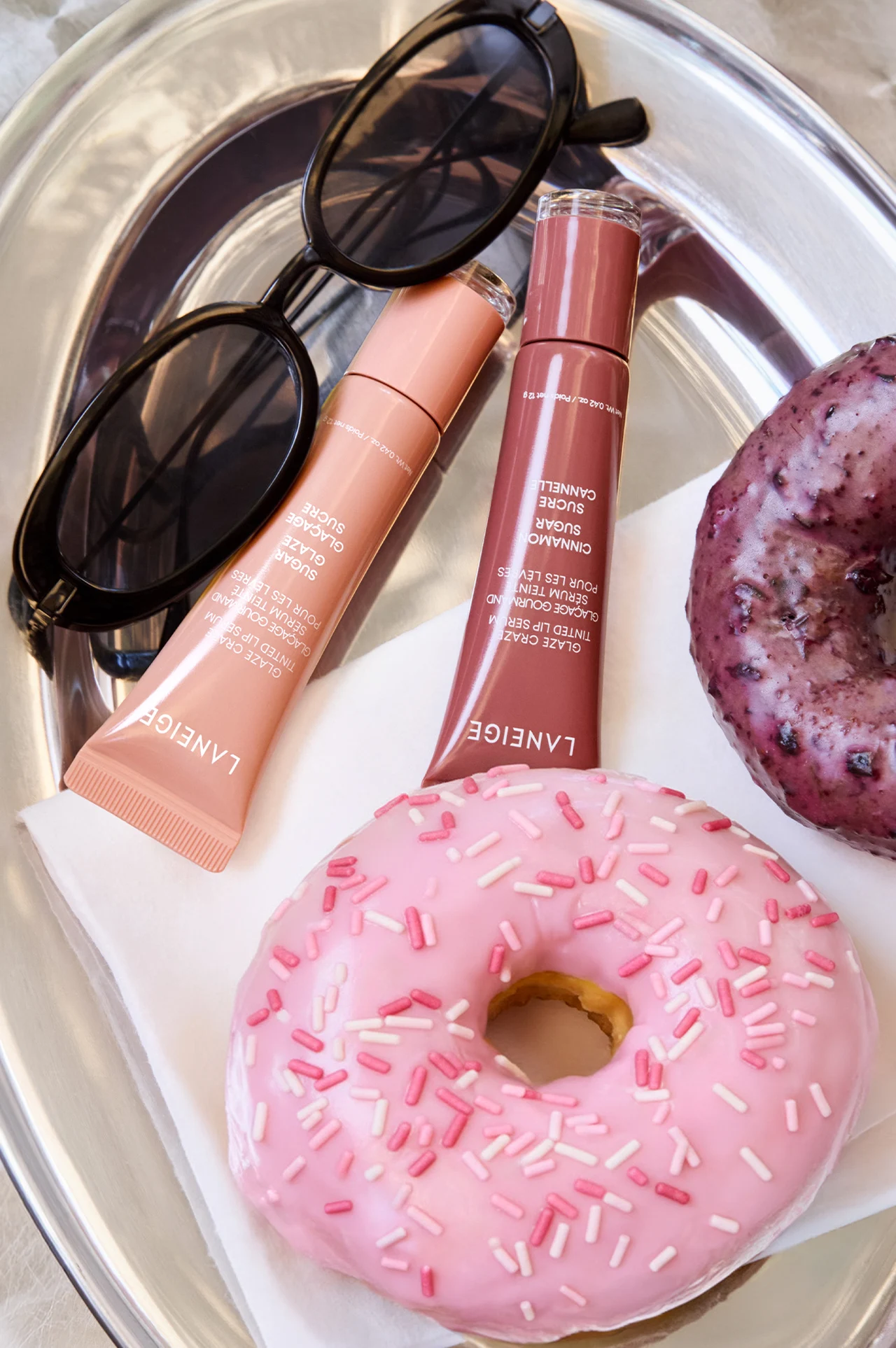 LANEIGE lip products beside sunglasses and a pink doughnut