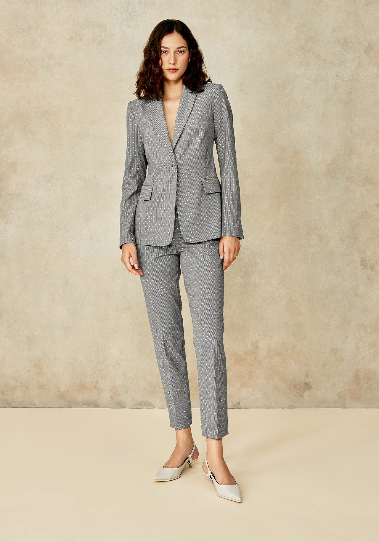 Full-length portrait in a gray tailored suit