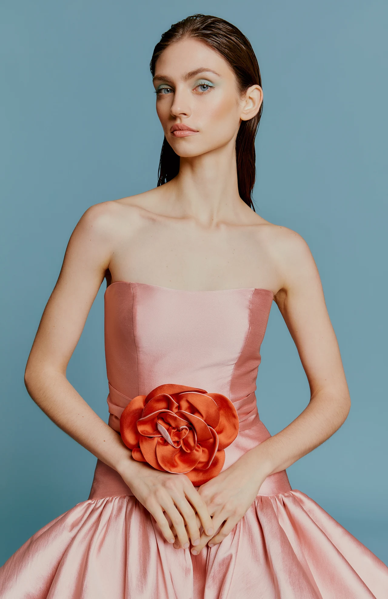 Portrait in a pink dress with a sculptural flower at the waist