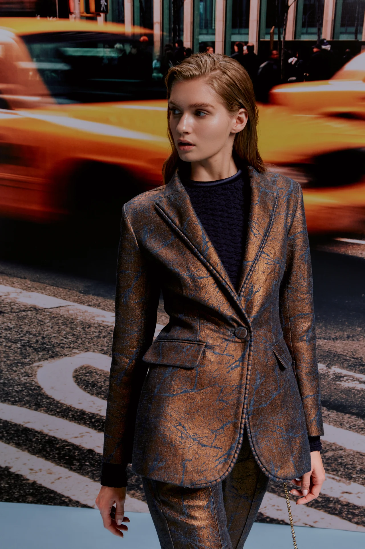 Model in a patterned suit against yellow taxis