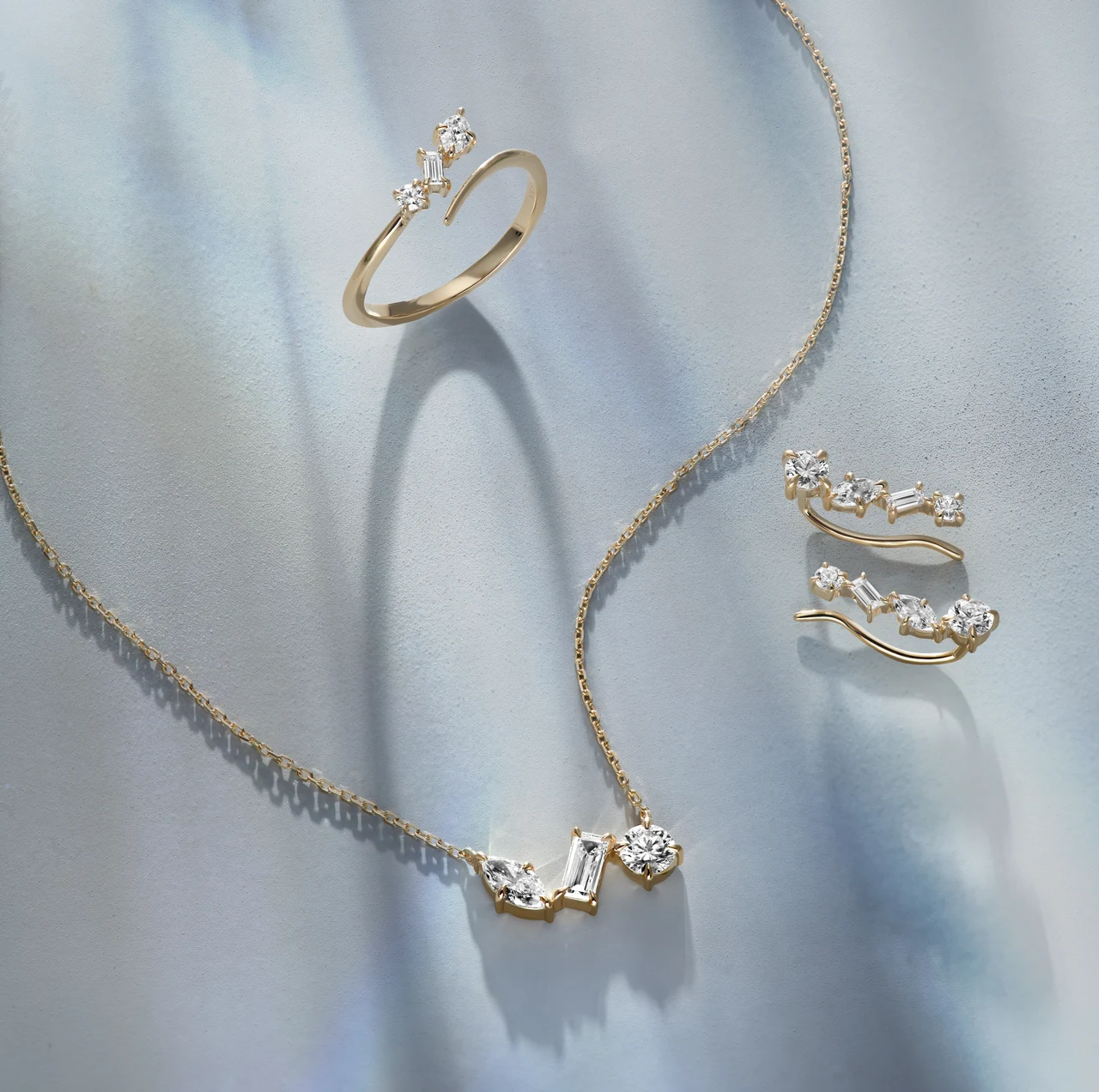 Gold necklace, ring and earrings in soft directional light